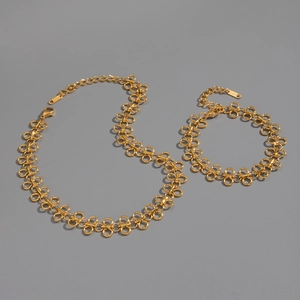 Detail of gold infinity loop link necklace and bracelet set in polished stainless steel