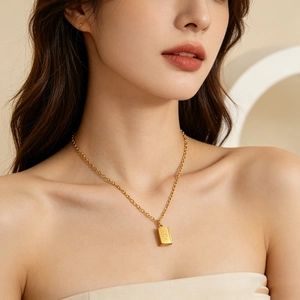 Close-up of 18k gold bible book pendant necklace worn by female model