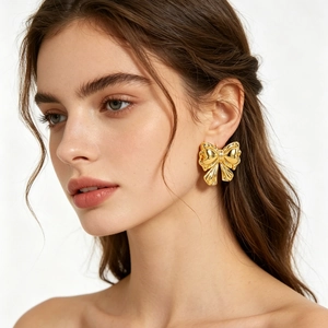 Elegant 18k gold plated bow stud earrings in stainless steel on female model