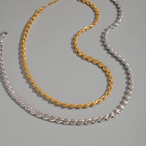 Detailed macro view of gold and silver twisted chain necklaces with lobster clasp and extender