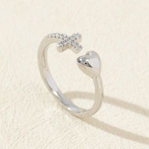 Detail of silver open ring featuring a smooth heart and zircon-encrusted cross