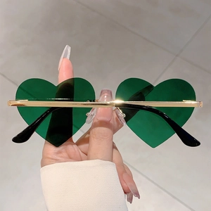 Detail view of heart-shaped green lenses with slim gold metal frame and black temple tips