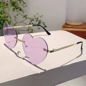 Detailed view of rimless heart-shaped sunglasses with purple lenses and gold metal temples