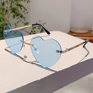 Detail of heart-shaped rimless sunglasses with light blue lenses and gold metal temples
