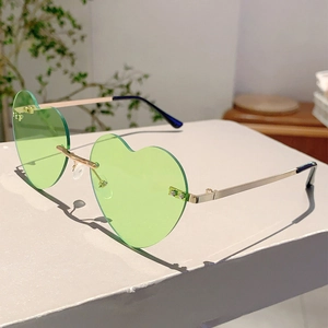Detail of light green heart-shaped rimless sunglasses with gold metal bridge and hardware