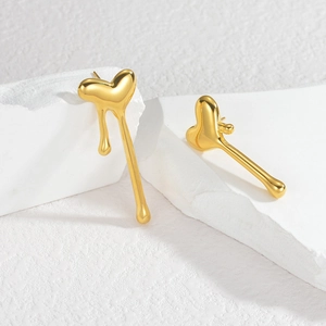 Boucles d'oreilles cœur lave doré à design fluide asymétrique sur support pierre