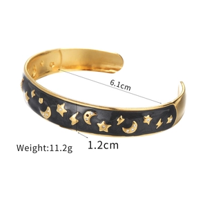 Bracelet manchette en émail noir avec motifs étoiles lune dorés et détails en zircon