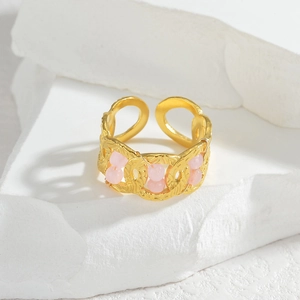 Bague croisée dorée géométrique avec perles roses et texture martelée sur pierre blanche