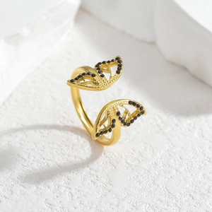 Minimalist open butterfly wing ring in gold finish with black stones on stone pedestal