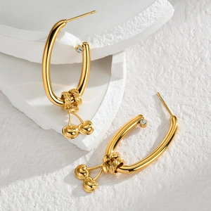 Golden cherry drop earrings with U-shaped hoops and sparkling zircon on white stone