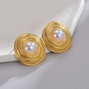 Retro gold geometric earrings with spiral texture and iridescent pearl on ceramic tray
