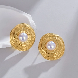 Vintage gold spiral textured round stud earrings with pearl centers on a white stone base