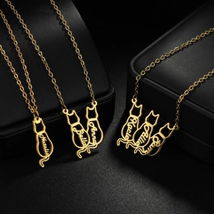 Macro detail of personalized cat necklaces in polished gold with custom name engravings