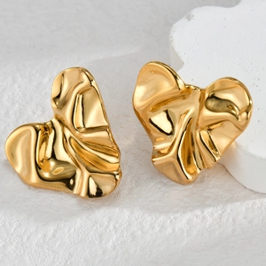 French vintage style heart stud earrings with gold pleated texture on stone background
