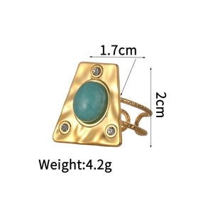 Detail of gold geometric ring with green oval stone and hammered texture finish
