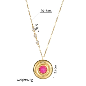 Détail macro du pendentif disque doré avec perle rose et diamants sur chaîne en acier titane