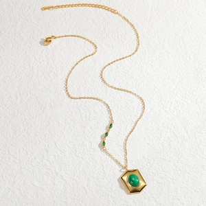 Collier minimaliste en acier doré avec pendentif hexagonal et pierres vertes serties