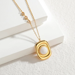 Collier vintage doré géométrique avec pendentif en nacre et petits détails en cœurs