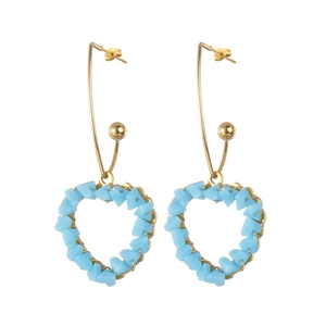 Boucles d'oreilles cœur dorées avec perles bleues et design géométrique sur fond blanc