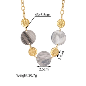 Detail of geometric necklace with marble resin pendant and gold solar metal disk