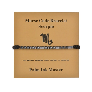 Detail view of Scorpio Morse code beaded bracelet on cardstock with zodiac chart
