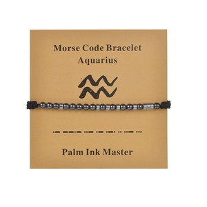 Detail of Aquarius Morse code bracelet with black cord and silver beads on display card