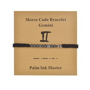 Detailed view of Gemini Morse code bracelet featuring black cord and hematite beads