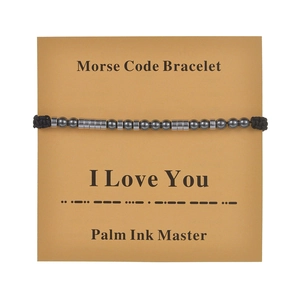 Detail of Morse code bracelet on kraft card showing I Love You symbol with beads