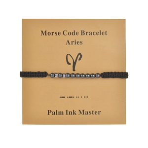 Handmade Aries Morse code bracelet with black obsidian beads on a kraft card
