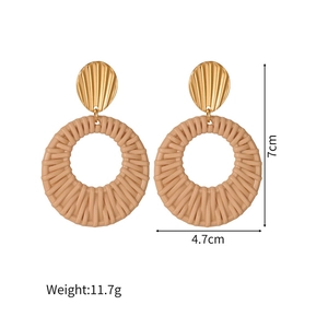Detailed view of woven rattan earrings with gold shell studs showing size 7cm by 4.7cm