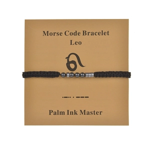 Detail of Leo Morse Code bracelet with black beads on a minimalist display card