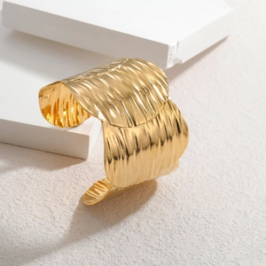 Irregular wide open cuff bracelet with 18K gold plating and rippled texture finish