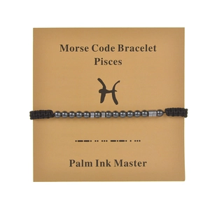 Detailed view of Pisces Morse code bracelet with obsidian beads on display card