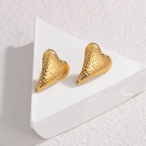 Textured gold hammered heart earrings in vintage style on white display stand