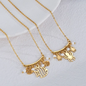 Golden spider and fish pendant necklaces with white beads on delicate link chains