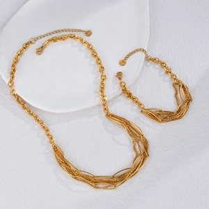 Macro view of gold multi-layer oval chain necklace and bracelet set with lobster clasps