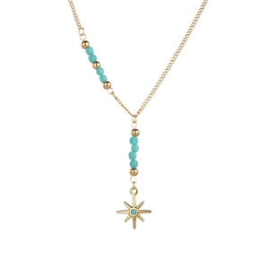 Detail of gold Y-necklace with blue beads and a star pendant with zircon center