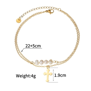 Macro detail of gold stainless steel double layered anklet with pearls and cross charm