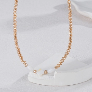 Collier de perles en cristal champagne avec pendentif trèfle blanc sur support en pierre