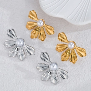 Boucles d'oreilles fleur or et argent avec perles blanches sur fond minimaliste