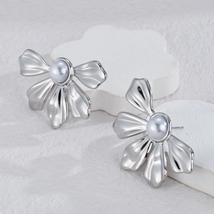 Boucles d'oreilles fleur argentées avec perles baroques sur des socles blancs