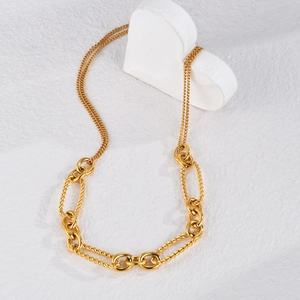 Collier minimaliste en acier titane doré avec chaîne mixte sur décor de cœur blanc