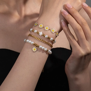 Vierteiliges Gold-Gänseblümchen- und Perlenarmband-Set für Damen am Handgelenk