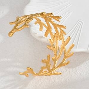 Vintage 18k vergoldetes Edelstahl-Armband im Korallenzweig-Design auf einer weißen Schale
