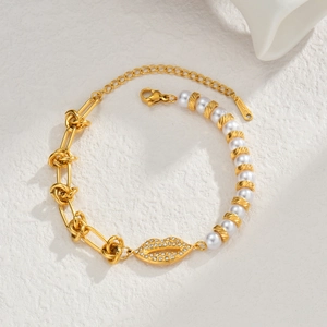 Macro detail of gold S-Steel bracelet with pearl beads, zircon lips, and textured links