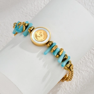 Detail of beaded bracelet with turquoise stones and mother of pearl butterfly charm