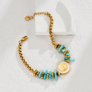 Macro shot of gold stainless steel bracelet with blue beads and elephant relief pendant