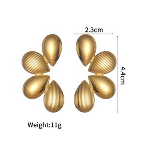Détail macro de boucles d'oreilles fleurs vintage plaquées or 18 carats de 2,3 cm x 4,4 cm