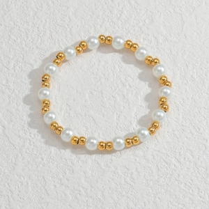 Makro-Detail des Perlenarmbands mit weißen Perlen und Goldakzenten auf weißem Hintergrund