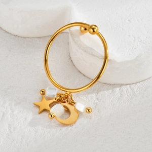 Detailed view of 18k gold earrings with crescent moon, star charms and white square beads